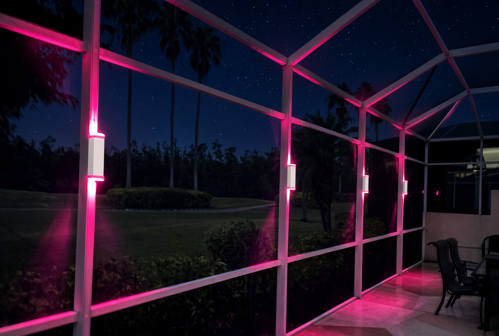 Permanent pool cage sconce lights in Pinellas County — magenta up-down wash on a Florida lanai at night
