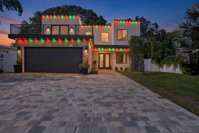 Permanent Christmas lights on a Pinellas County home — holiday color on the roofline at night