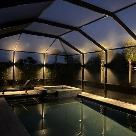 Lanai sconce lighting on a Florida pool cage — architectural wall wash at night