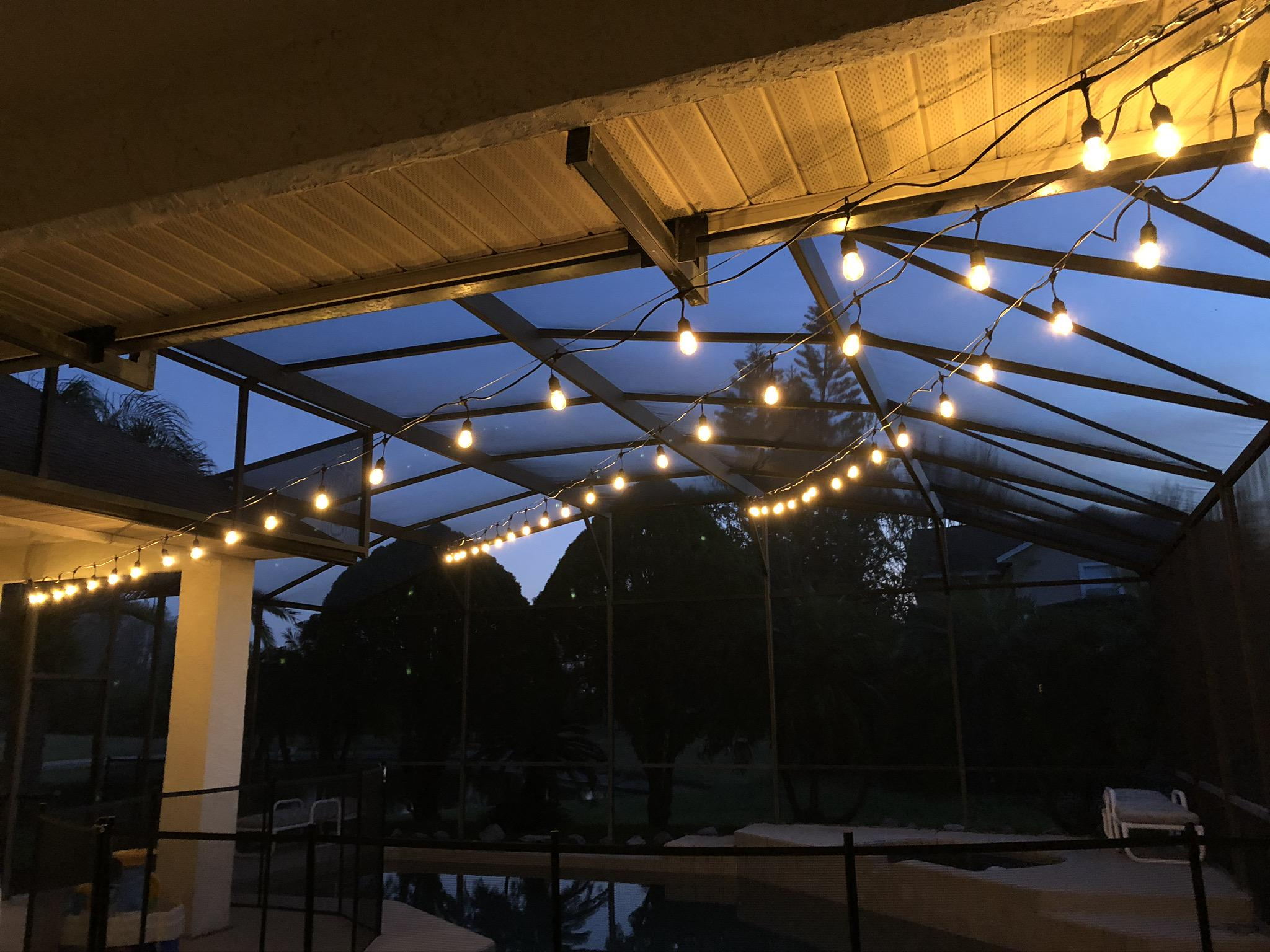 Example of cheap temporary string lights on a pool cage — sagging strands that don’t belong on a nice Florida home